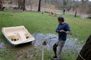 Carlos Frutis secures a paddle boat in preparation for flooding at his friend's property on the banks of the Russian River in Forestville, Calif., Sunday, Jan. 8, 2023. (Beth Schlanker/The Press Democrat file)